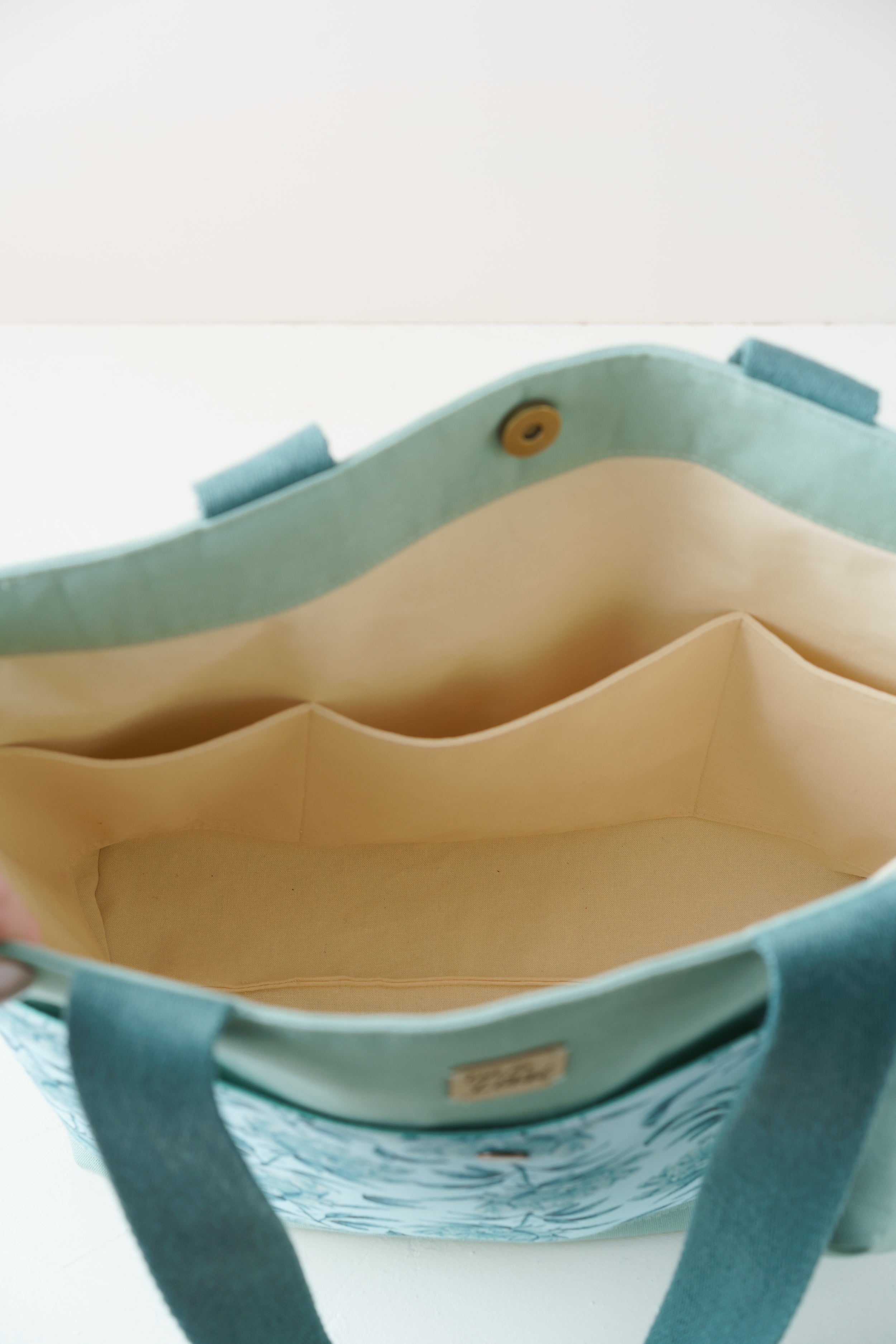 Türkiser Shopper mit Pfingstrosenmuster und Taschenbaumler