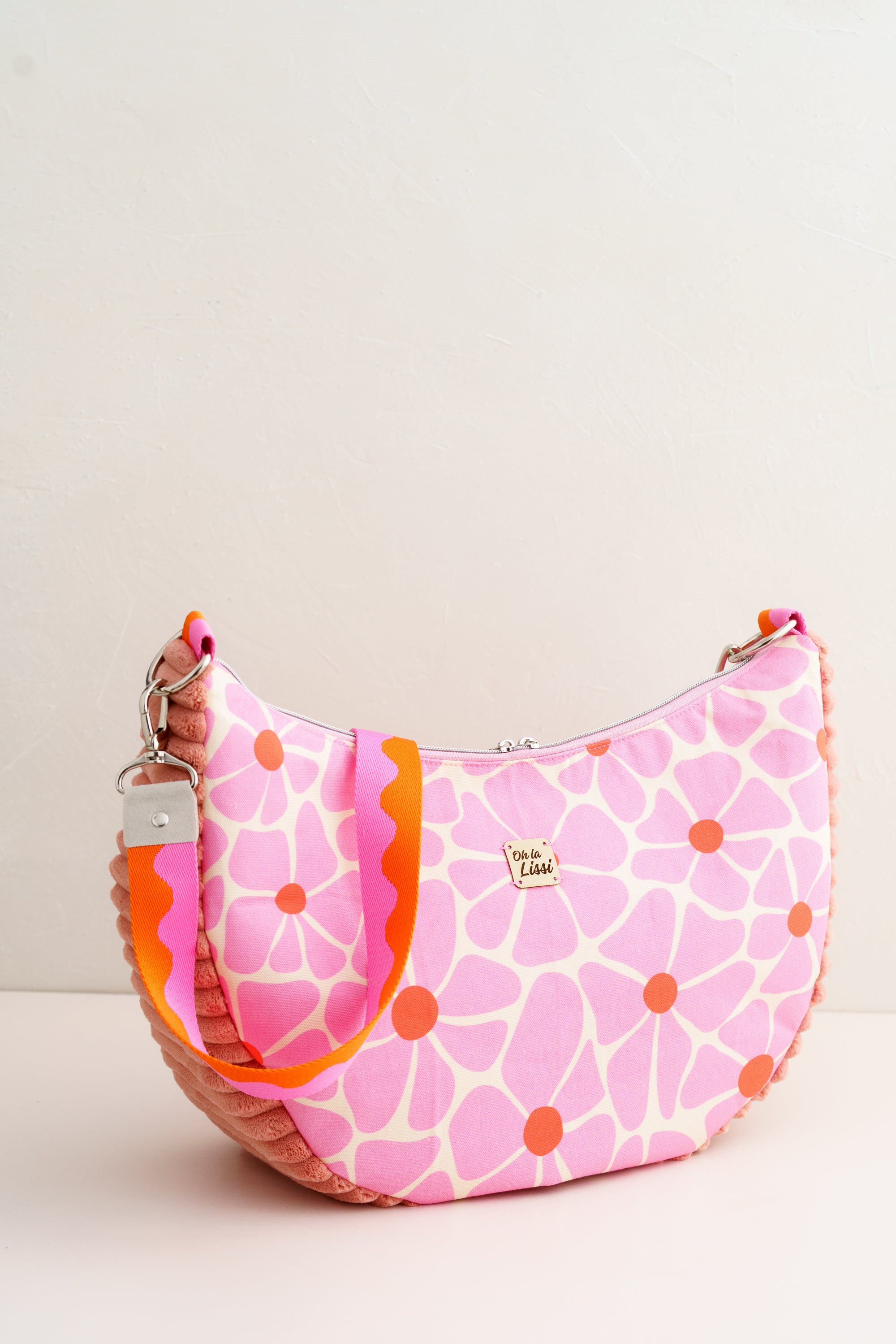 Handgemachte Halbmond Tasche für Damen aus Baumwollstoff mit rosa Blumenprint und orangefarbenen Punkten, moderne Schultertasche mit Reißverschluss.