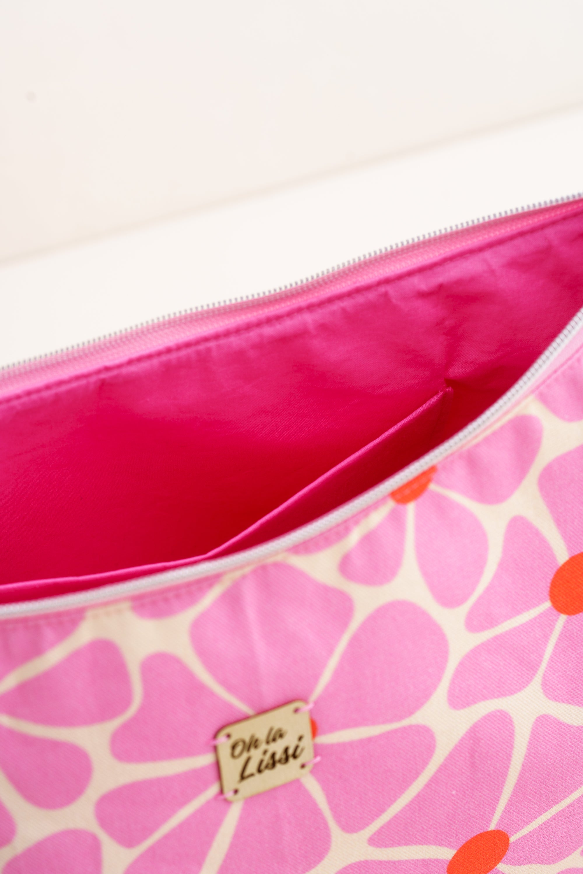 Innenansicht einer handgemachten Stofftasche für Damen mit pinkem Innenfutter, Reißverschluss und praktischem Innenfach.